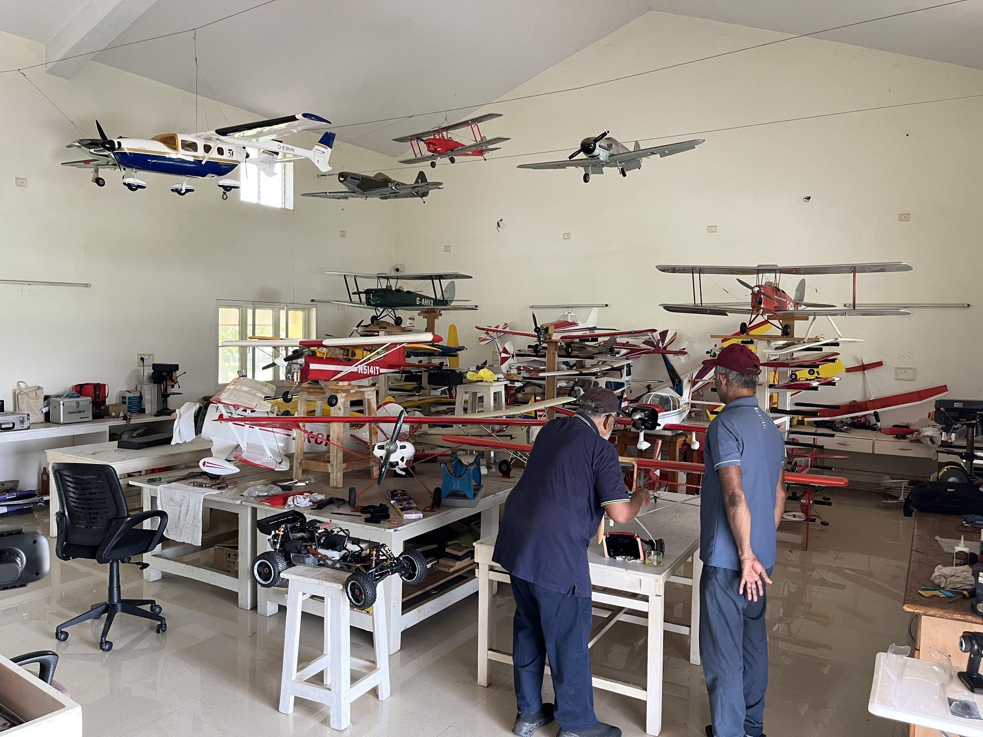RC aircraft workshop — dozens of planes hanging from ceiling